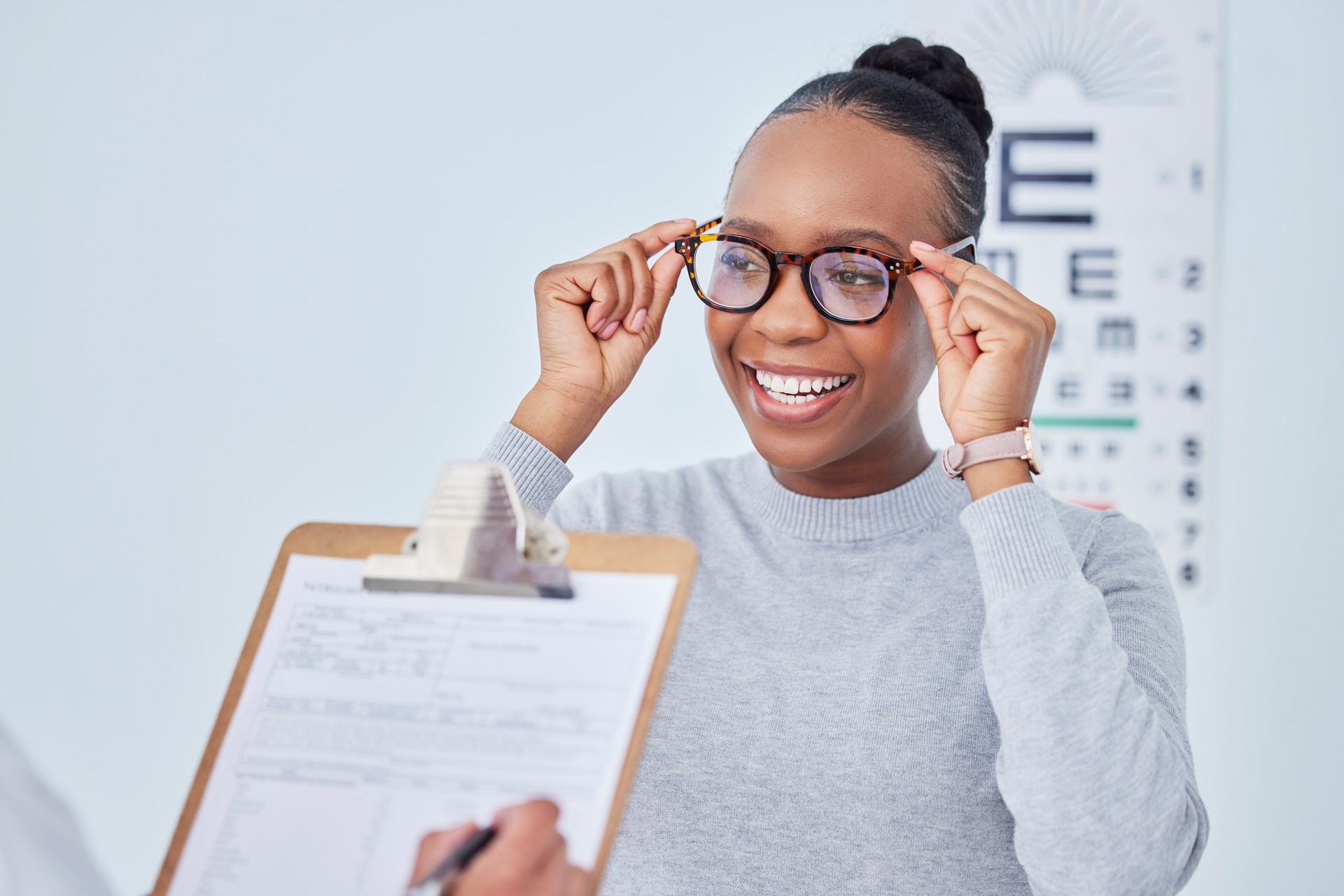 Black woman, glasses and vision, clipboard and optometrist with health insurance, prescription lens and frame. People at clinic, optometry and writing, checklist and info with eye care and documents